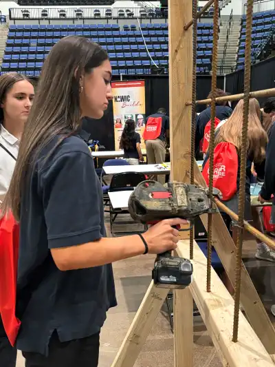 Student holding a construction tool.